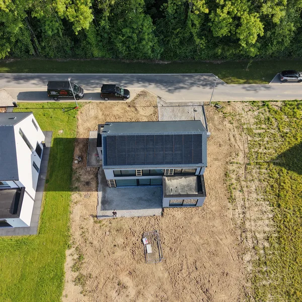 Vue aérienne en plongée de la maison et de son installation photovoltaïque avec la camionnette Debelec