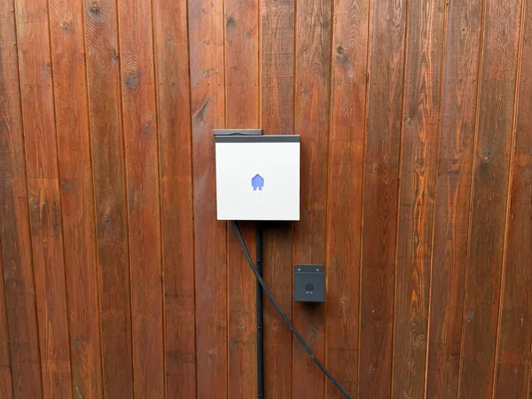 Borne de recharge Smappee installée par Debelec sur le bardage bois d'une habitation à Godinne