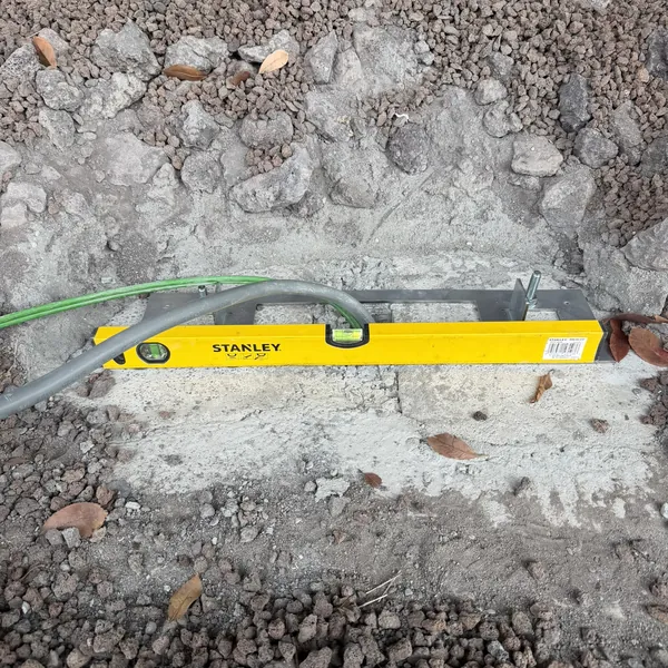 Niveau posé sur le socle béton et câblage d'une borne de recharge à l'Orange Hotel