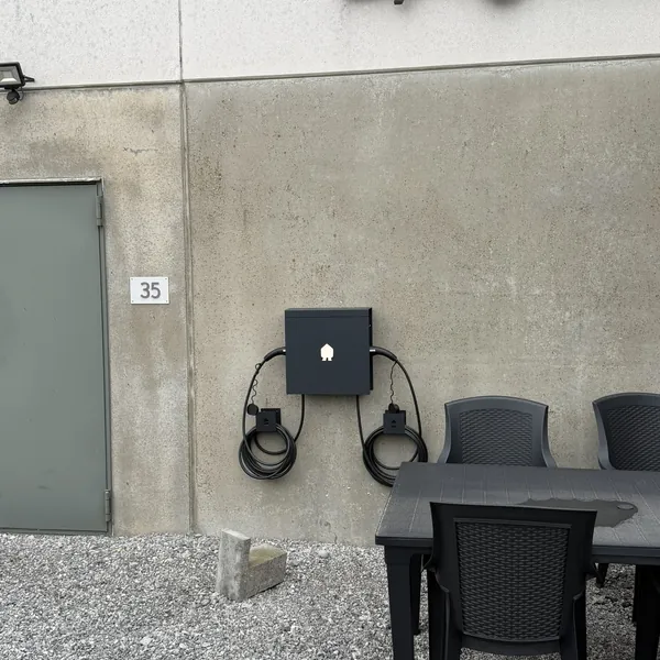 Borne double Smappee noire en façade, à côté de la terrasse de Vicollect à Sombreffe