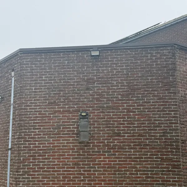 Projecteur LED 50 W noir mat installé sur la façade en brique du Centre Paramédical